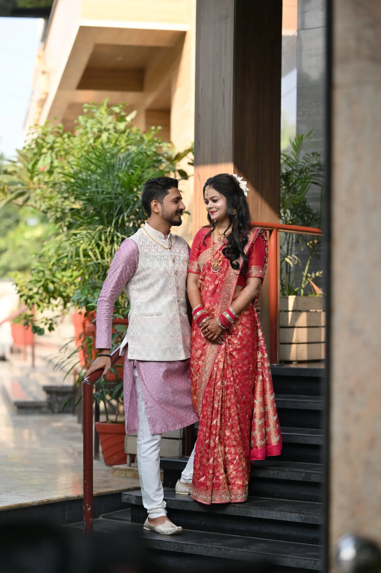 Newlywed couple in traditional wear on a staircase