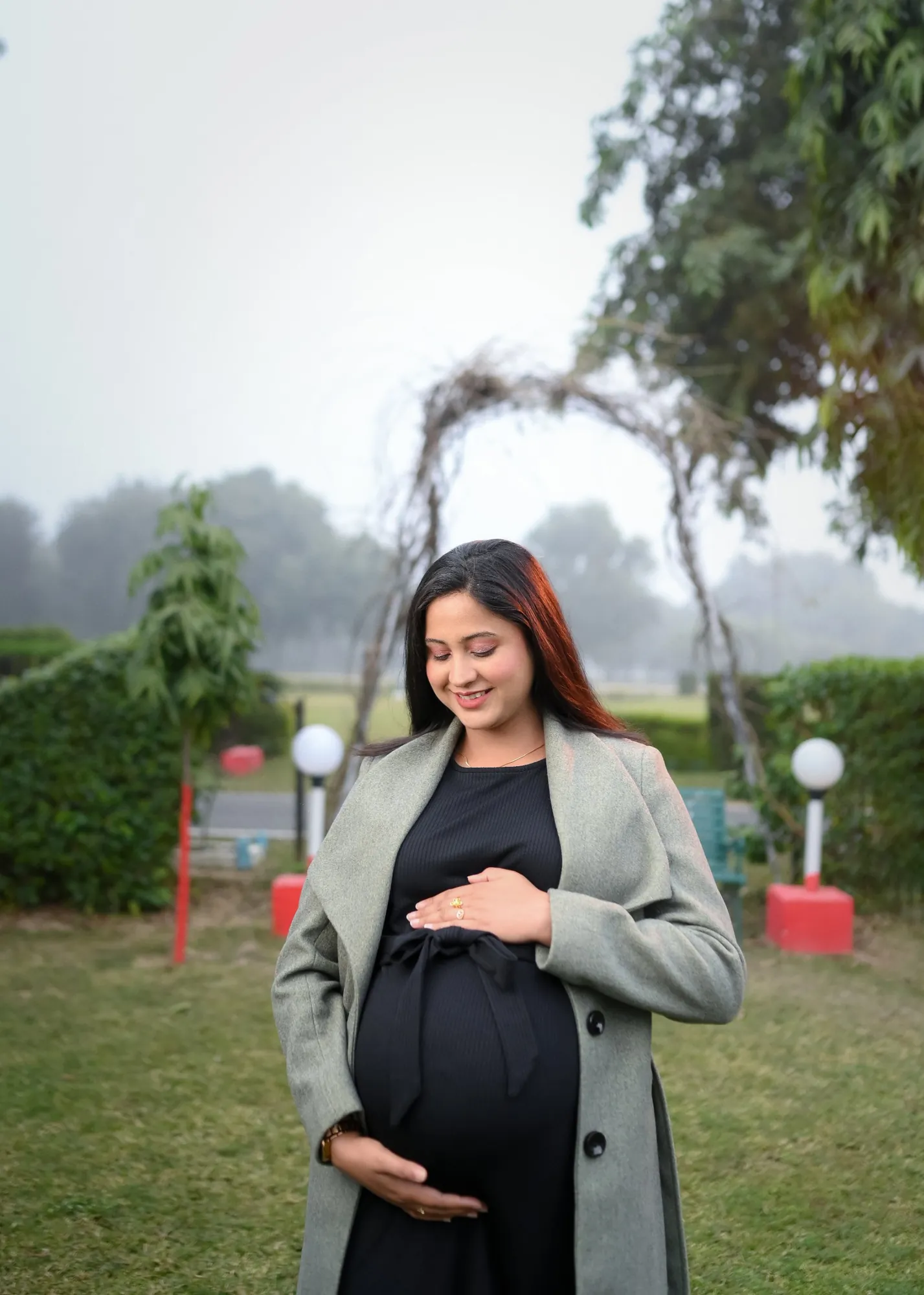 Mother-to-be in a grey coat on a misty winter morning