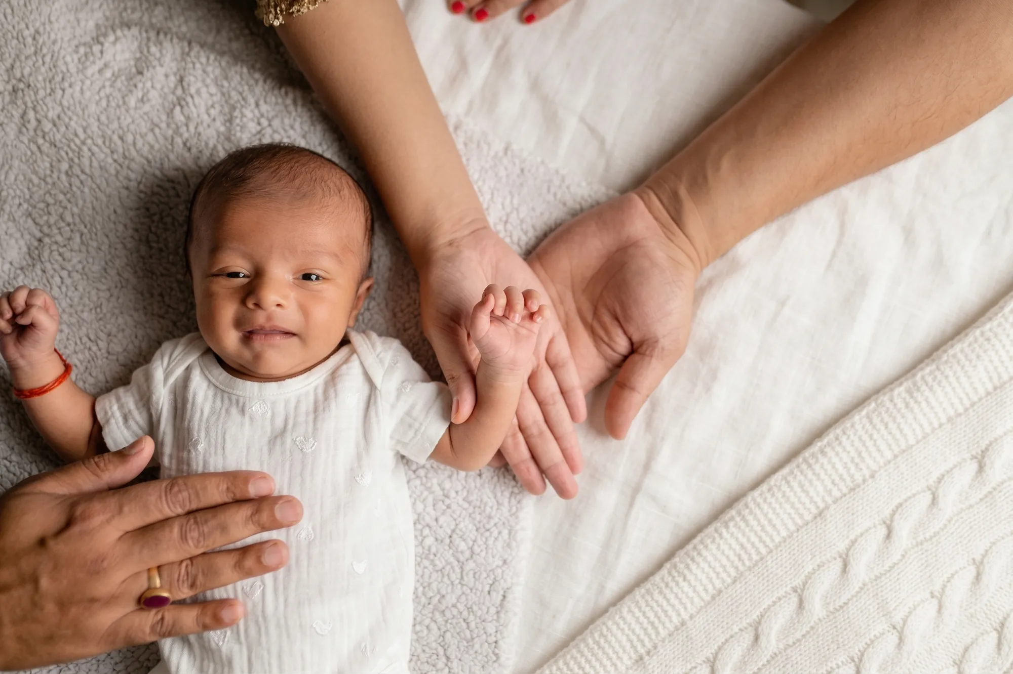 Newborn with mum and dad's hands