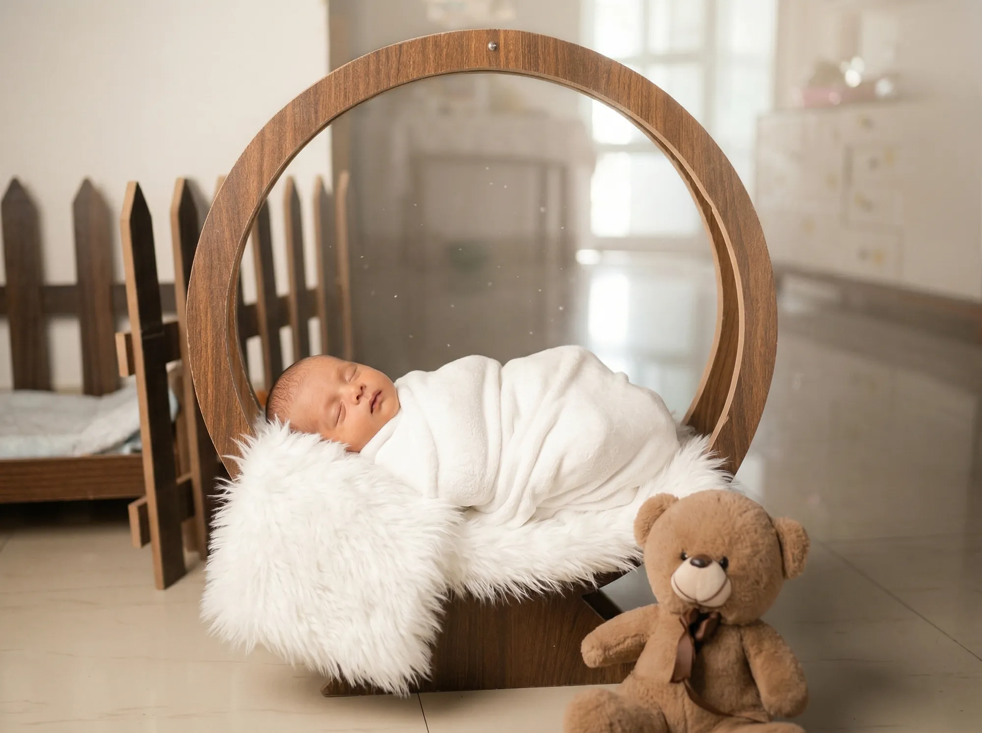 Newborn asleep in a wooden ring on a soft fur throw