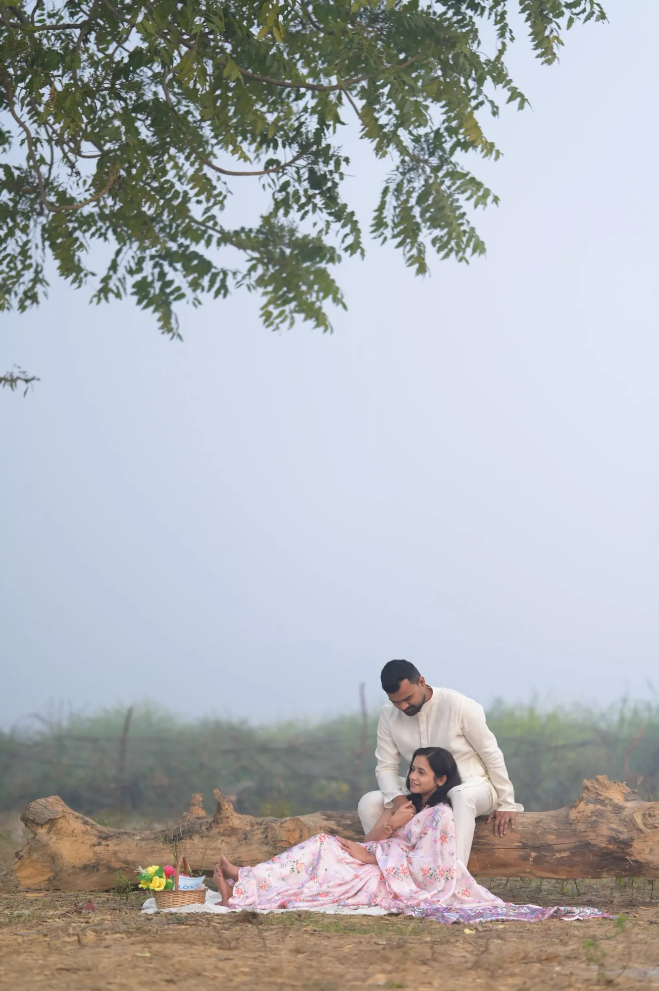 Couple on a misty morning picnic under a tree