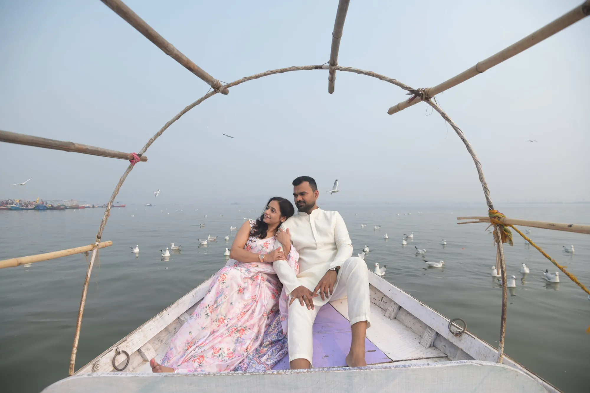 Couple on a boat under a bamboo canopy at the Sangam, Prayagraj